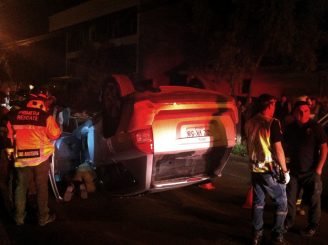 Violenta colisión deja automóvil volcado en plena calle y menor lesionado